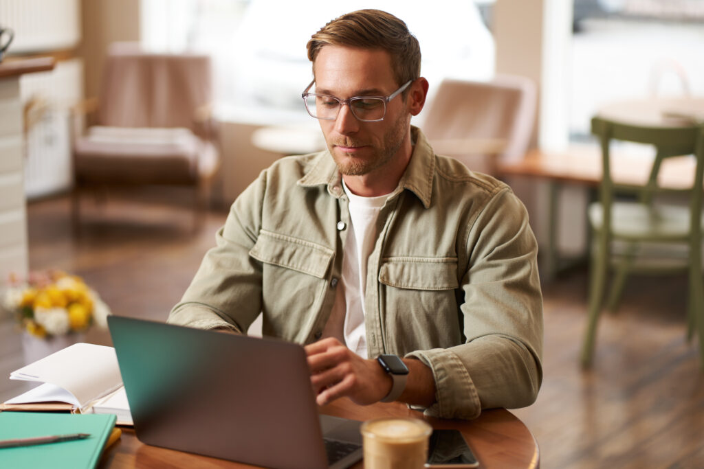 WordPress vs Zoho Sites: Which Is Better for Building Websites? 3 remote-work-freelance-concept-handsome-man-glasses-sits-with-notebook-laptop-studying