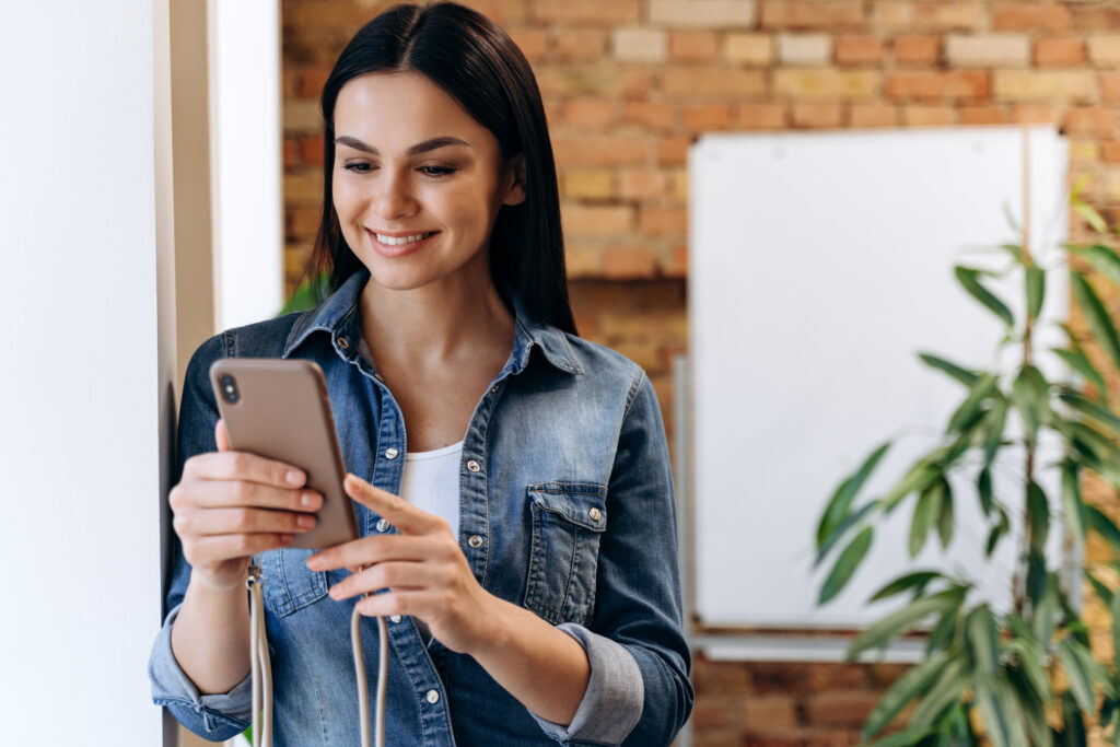 Female manager looking information at cellphone indoors