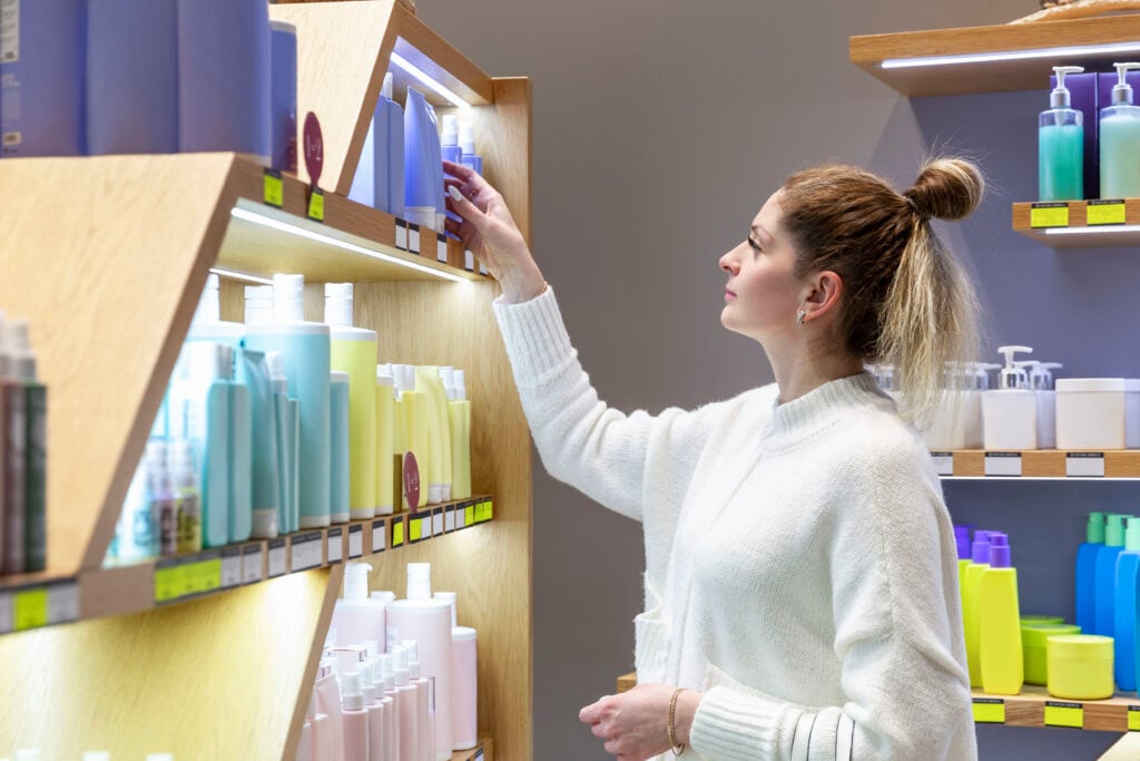 A young woman chooses a cosmetic product in a store. Beautiful s