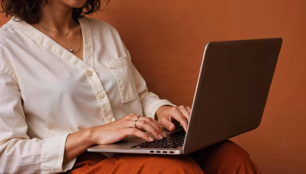 Focused woman working on a laptop in a softlit environment